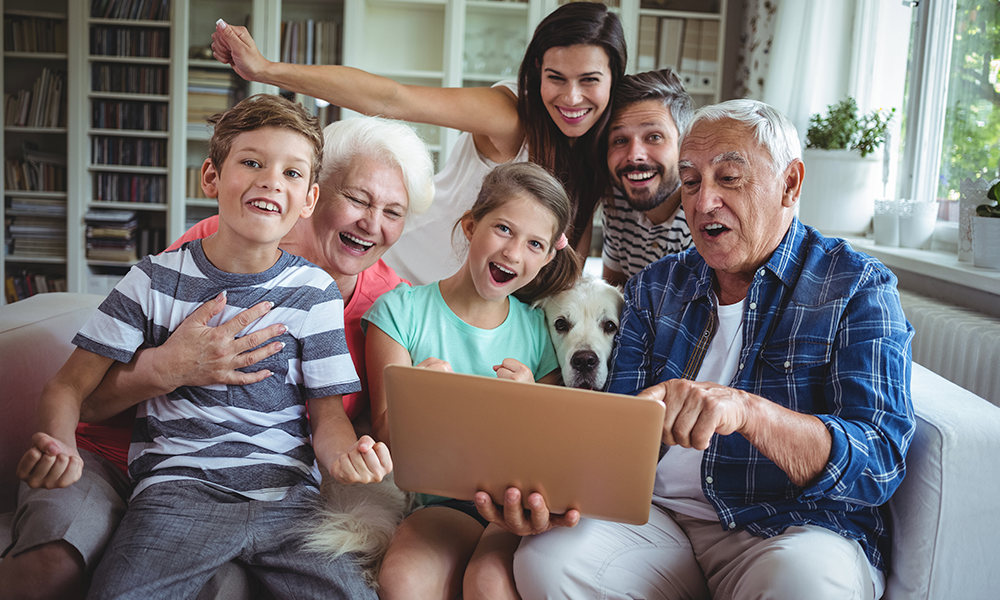Família reunida no sofá usando um notebook